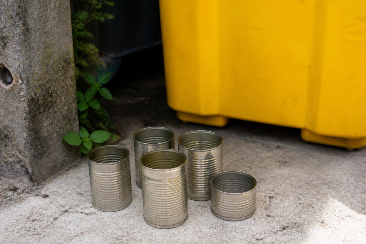 Boites metalliques vides rincees pres d'une poubelle jaune