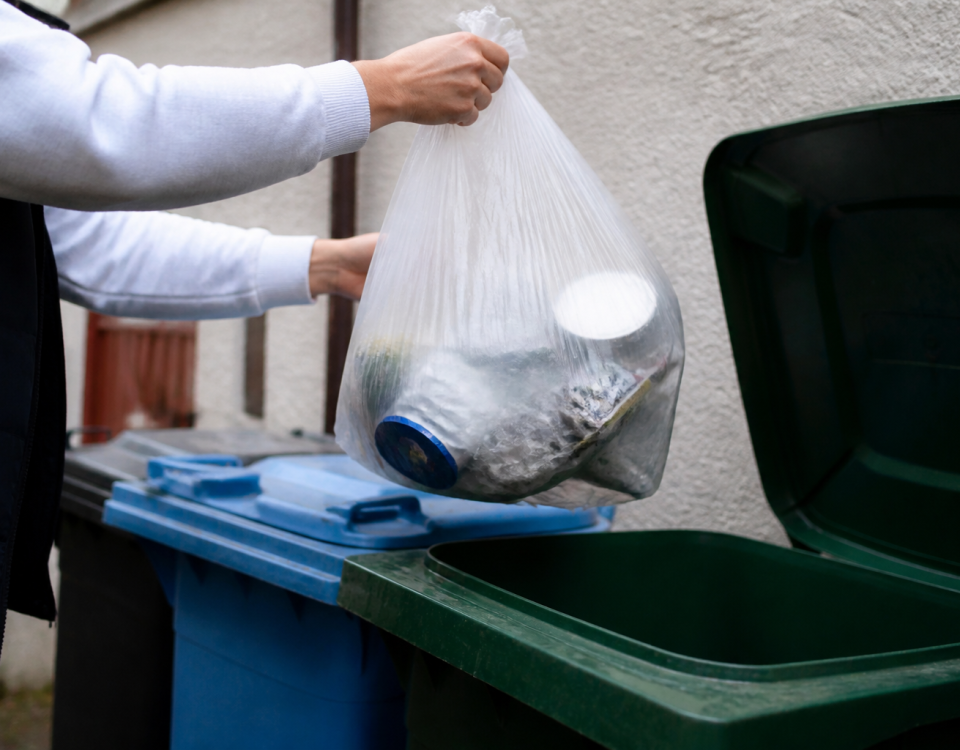 Main tenant un sac transparent au-dessus bac recyclage