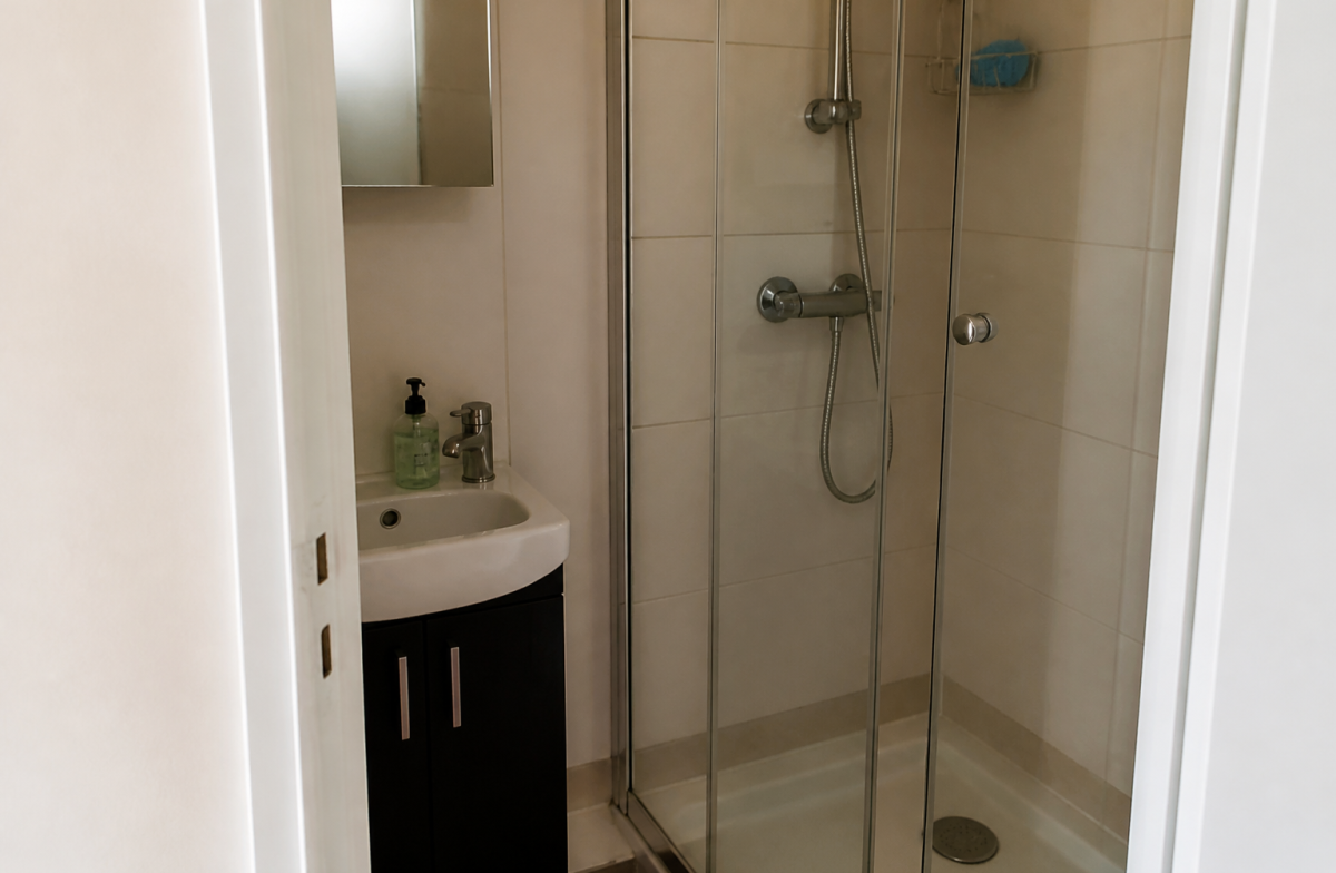 Petite salle de bain avec lavabo et douche compacte