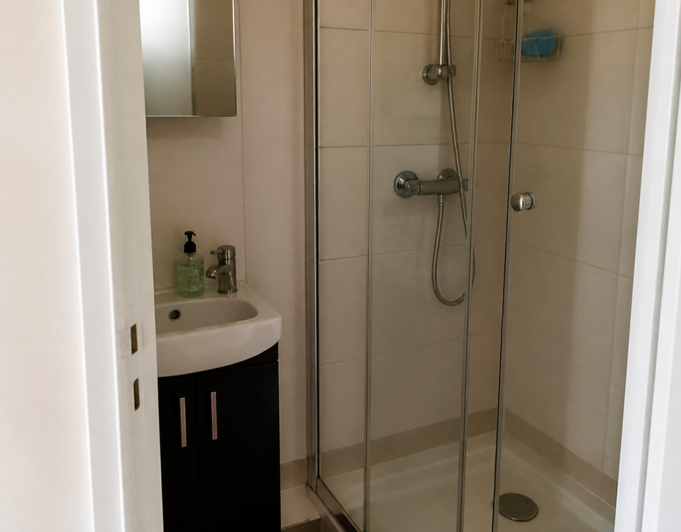 Petite salle de bain avec lavabo et douche compacte
