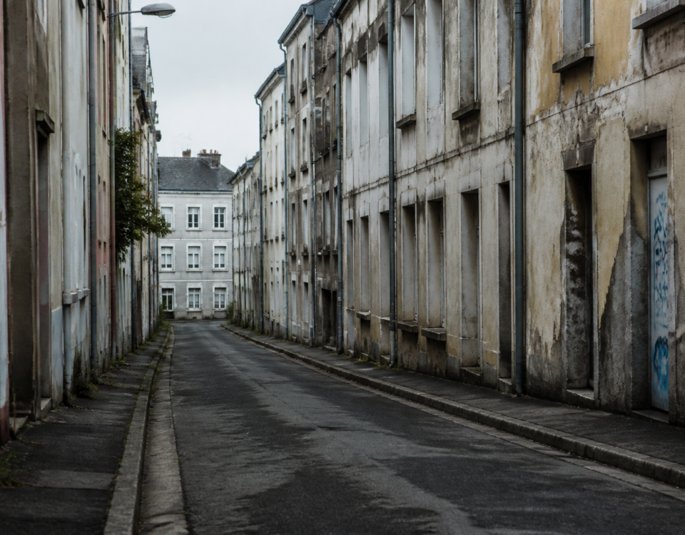 Rue sombre de Brest avec immeubles delabres et deserts.