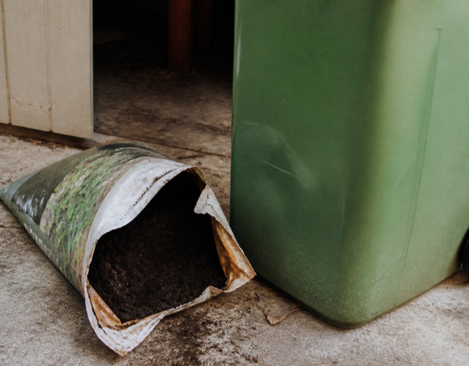 Sac de terreau ouvert pres d'une poubelle verte