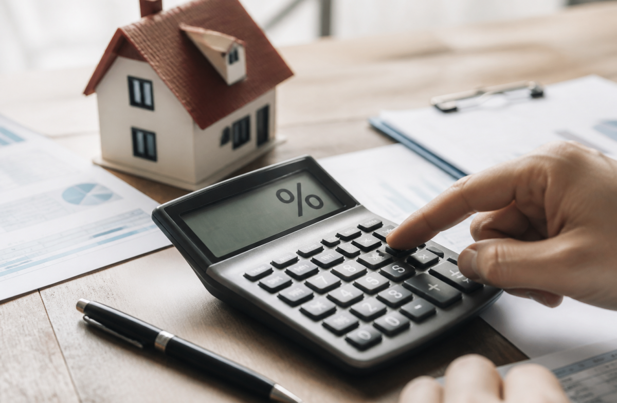 Calculatrice affichant pourcentage avec documents immobiliers et chiffres