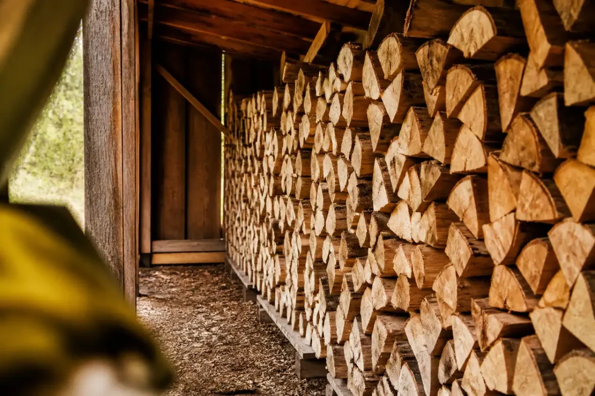 Buches fendues empilees en rangees sous un abri